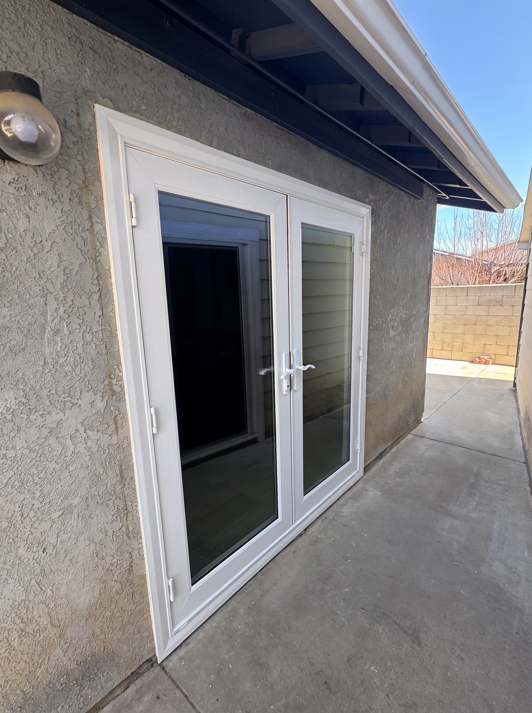 White hinged French doors set in a stucco wall