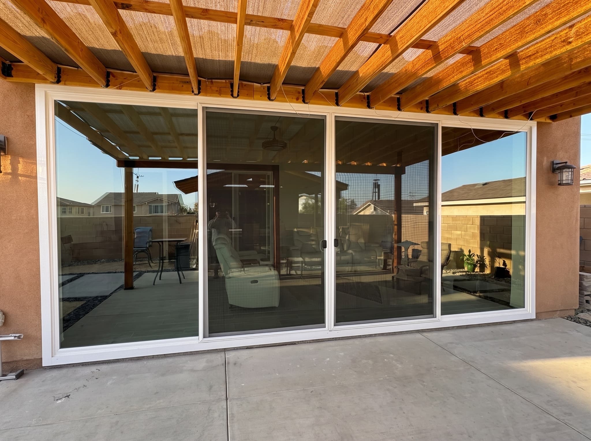 Four-panel sliding patio door under a wood pergola