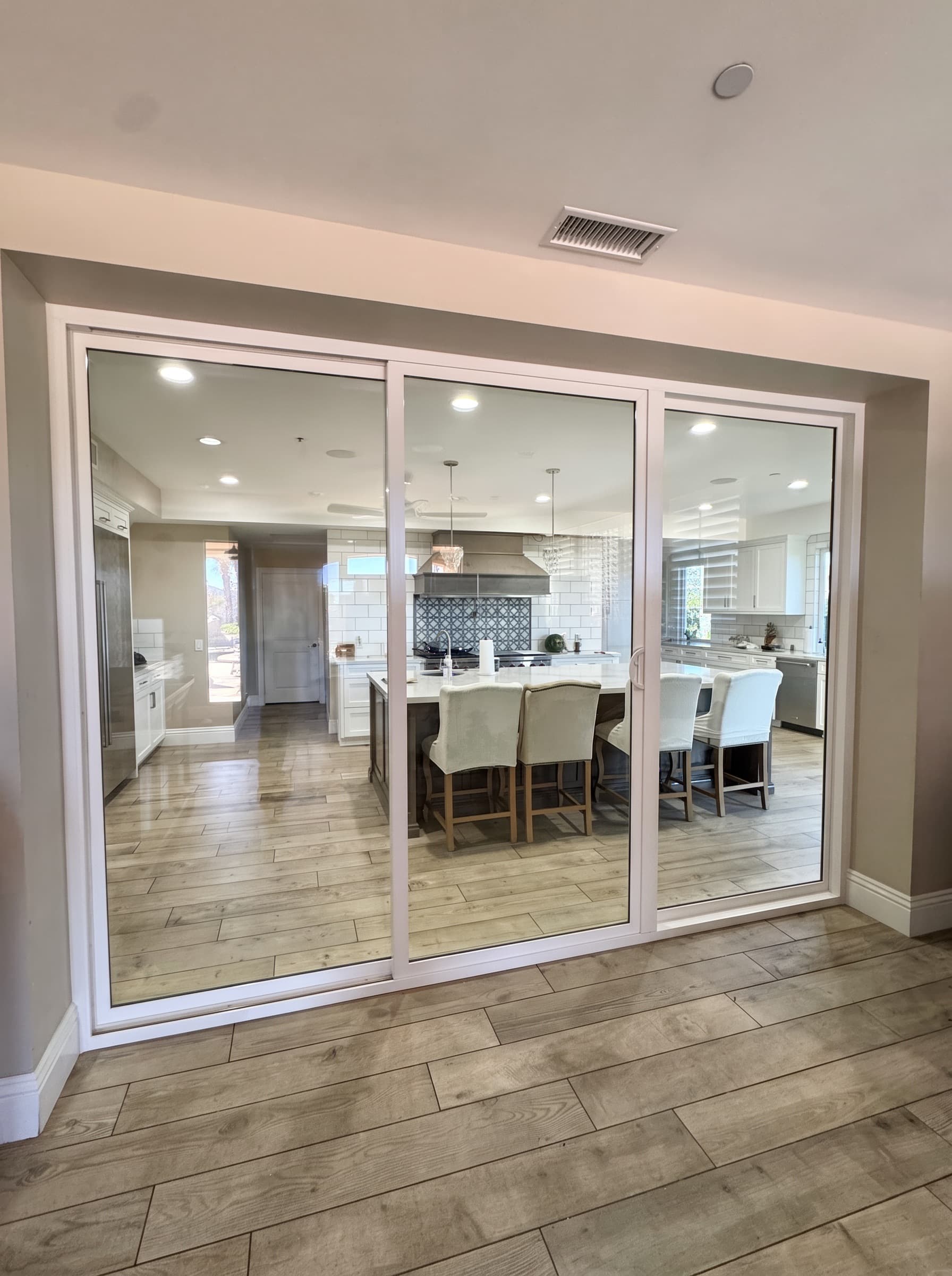 Three-panel sliding glass door opening into a kitchen